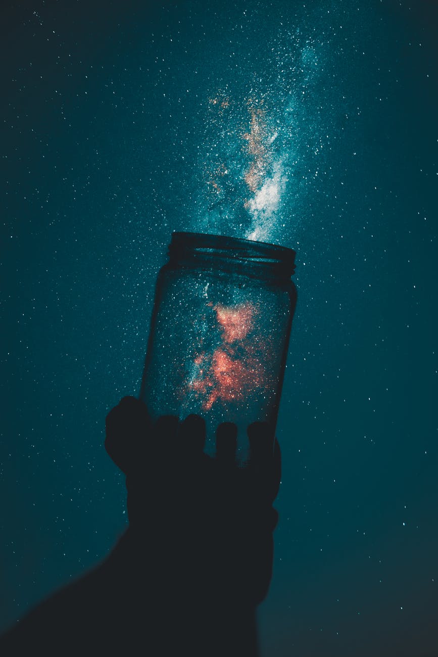 silhouette of person holding glass mason jar