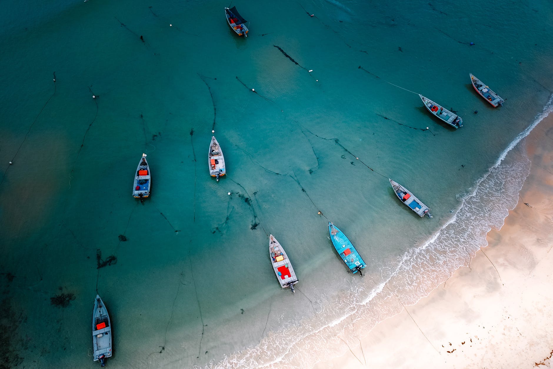 boats floating near sandy sea coast