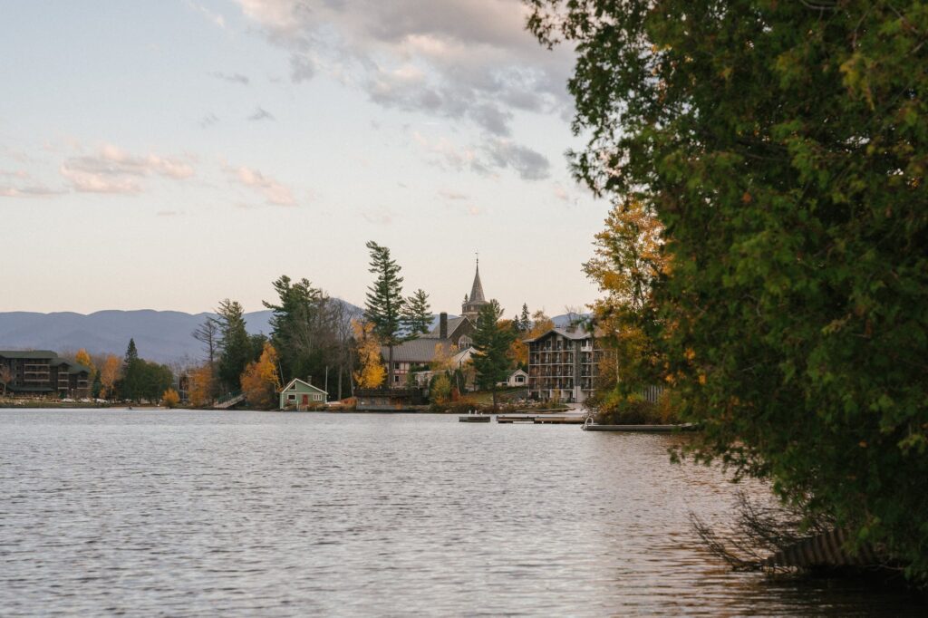 peaceful lake with residential cottages and lush trees on shore in autumn