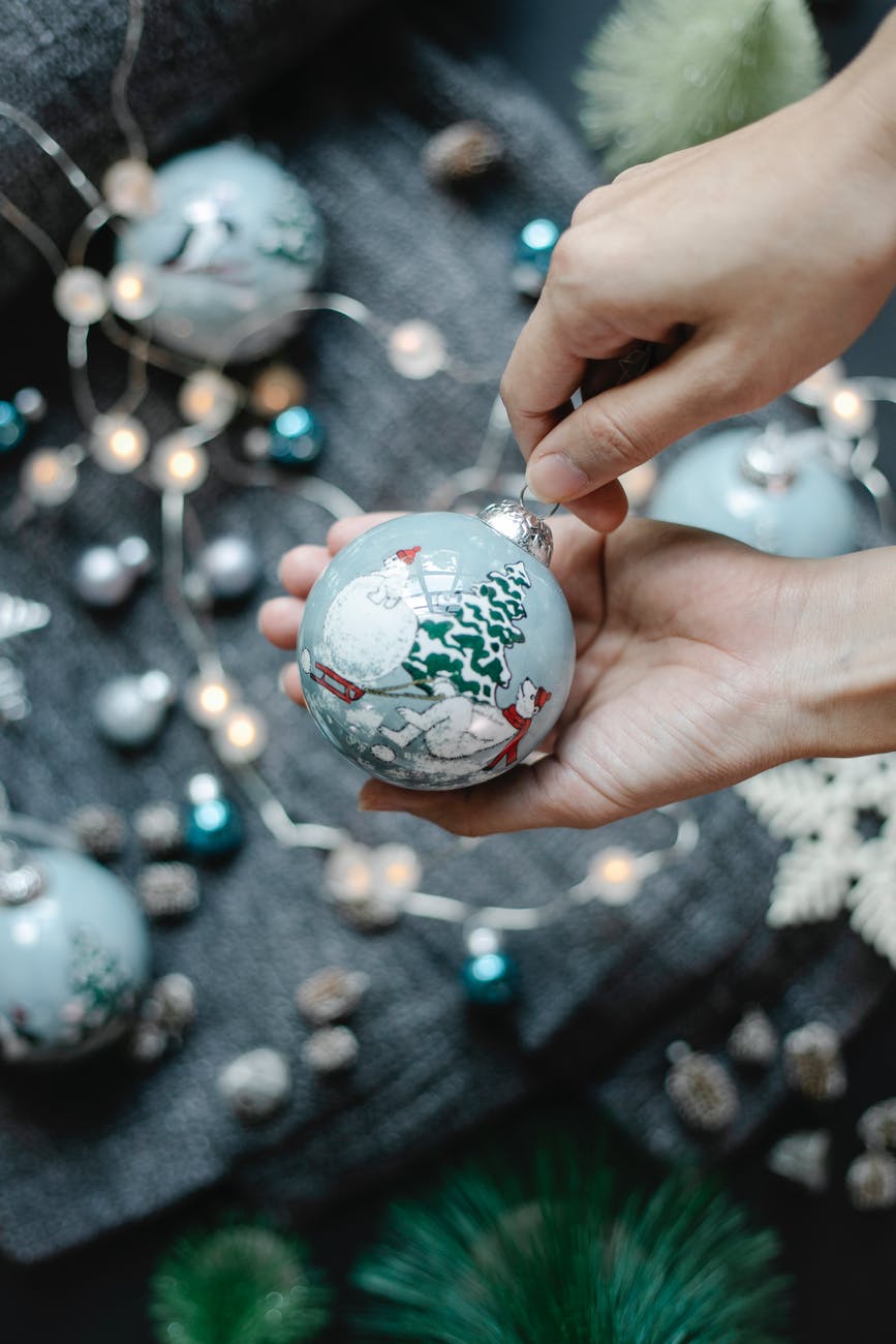 anonymous person near christmas decorations with balls