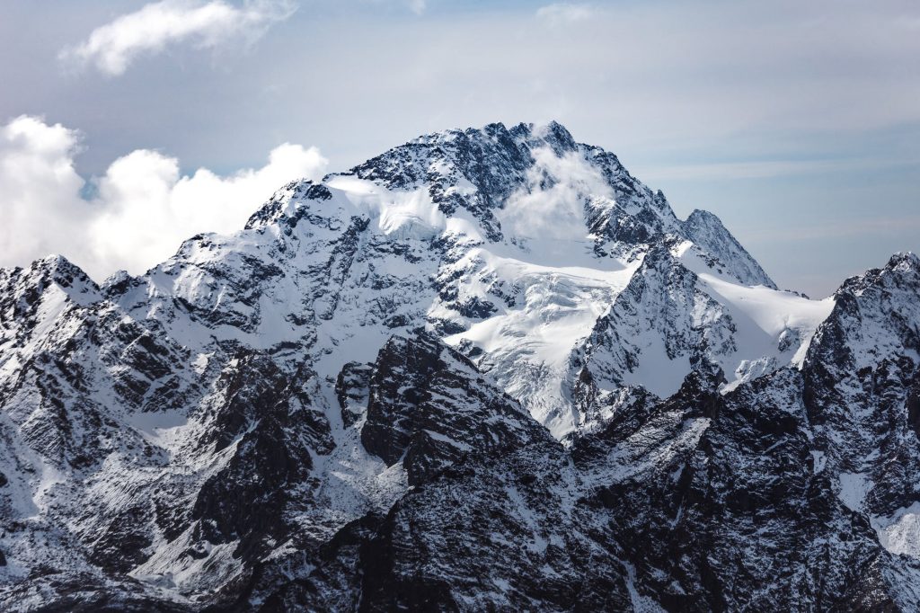 snow covered mountain under cloudy sky