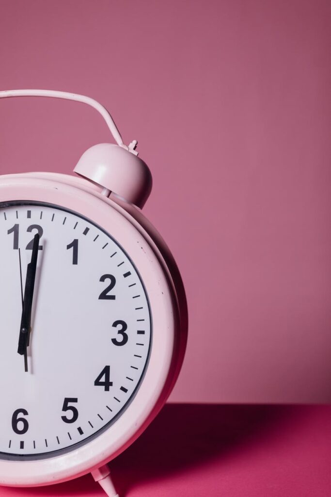 close up photo of pink alarm clock