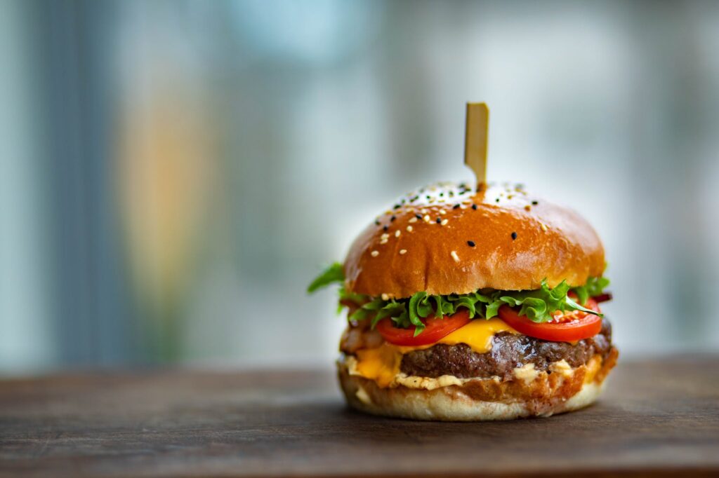 photo of juicy burger on wooden surface