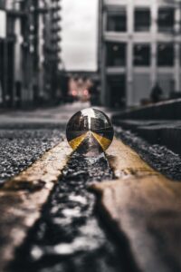 selective focus photo of lensball on asphalt road