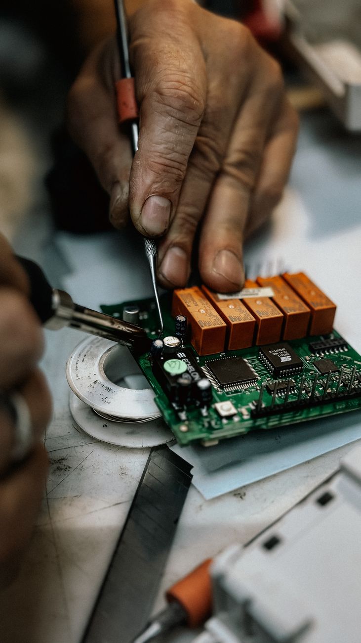 close up of hands repairing circuit board with precision