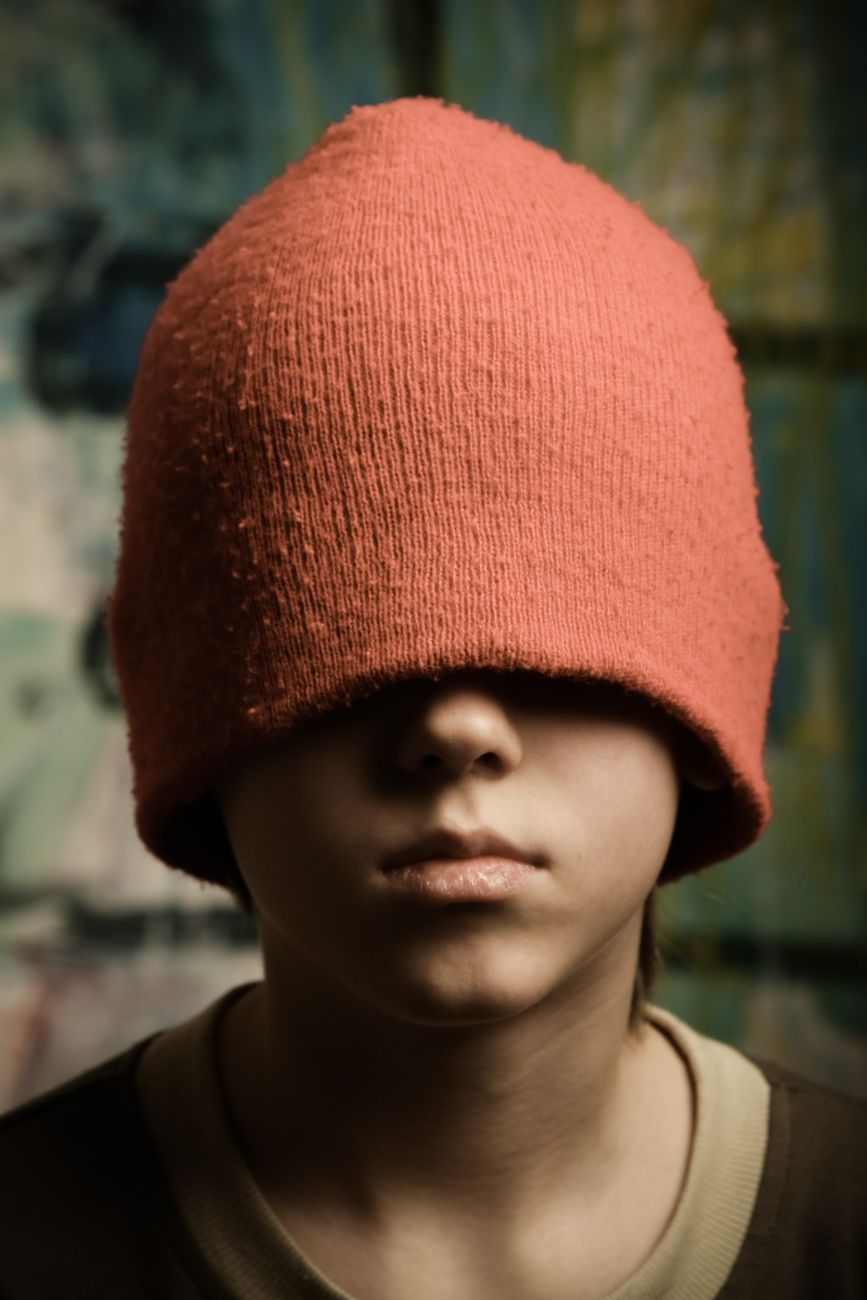a person covering his eyes using a beanie